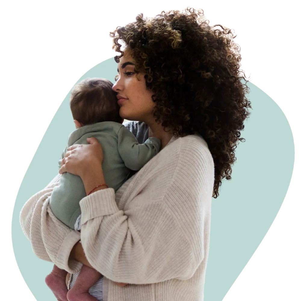 A mother holding her infant against her shoulder, her eyes closed