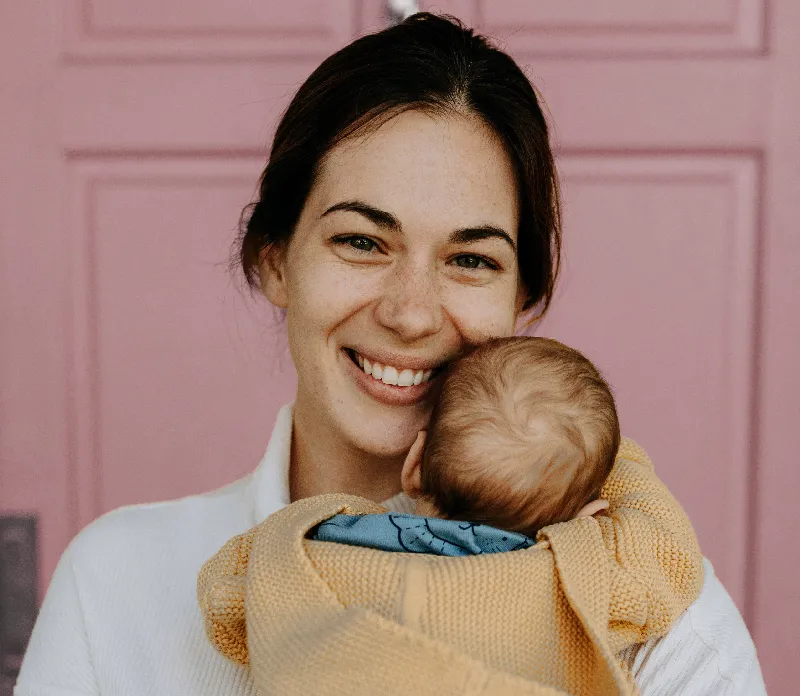A smiling mother holding her infant close